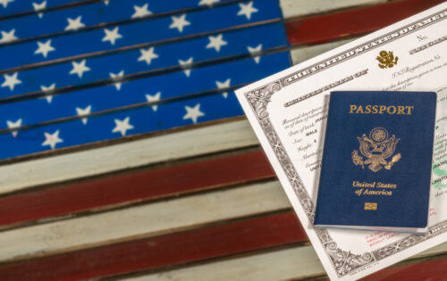USA passport and naturalization certificate over US Flag