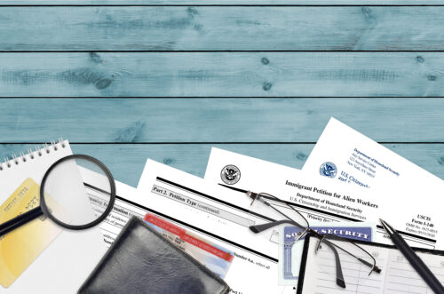 USCIS form I-140 Immigrant petition for alien workers lies on flat lay office table and ready to fill. U.S. Citizenship and Immigration services paperwork concept. Top view