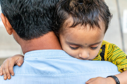 refugee with his sick child at a border
