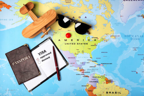 Passports, sunglasses and toy airplane on map. Approved American visa